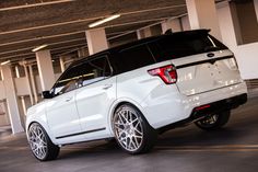 a white suv parked in a parking garage