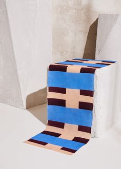 a blue and brown object sitting on top of a white floor next to a wall