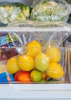 an open refrigerator with fruits and vegetables in plastic bags