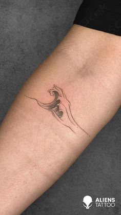 a woman's arm with a wave tattoo on the left side of her body