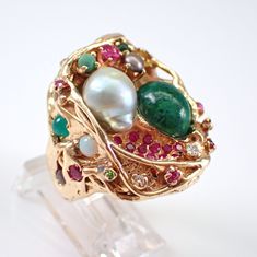 "Vintage Solid 14k Yellow Gold Baroque Pearl and Jade Cluster Ring. This ring is set with two main gemstones that include a Baroque Pearl and an Oval Cabochon Jade.  The ring is set with multi color gemstones throughout.  These gems include Diamonds, Rubies, Emeralds, Rhodolite Garnets, Opal, Sapphires and Citrine.  All the gemstones are genuine and set in an abstract design. This ring weighs 28.6 grams, measures 27 mm along the finger (a little over 1\") and is a finger size 5 1/2, which can be Collectible Green Multi-stone Jewelry, Unique Multi-stone Emerald Ring, Unique Multi-stone Emerald Anniversary Ring, Unique Multi-stone Emerald Jewelry, Fusion Multi-stone Jewelry For Anniversary, Unique Multi-stone Emerald Ring For Formal Occasions, Fusion Style Multi-stone Jewelry For Anniversary, Unique Multi-stone Jewelry For Anniversary, Fine Jewelry Emerald Multi-stone