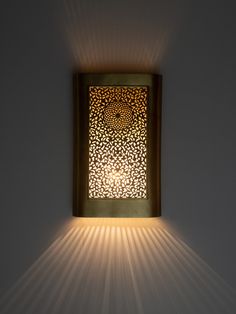 a light that is on the side of a wall with a shadow coming from it