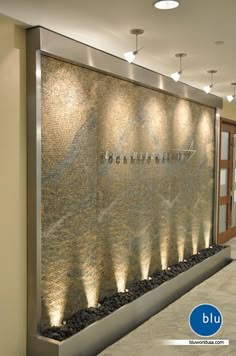 a wall fountain with lights on it in a lobby or office building that is well lit