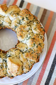 a white plate topped with a bagel covered in cheese