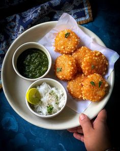 a white plate topped with fried food and dipping sauce