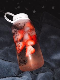 a plastic bottle filled with liquid and strawberries