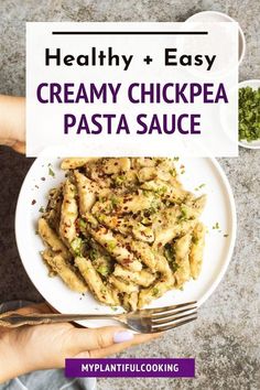 a white plate topped with pasta next to a bowl of pesto sauce and a fork