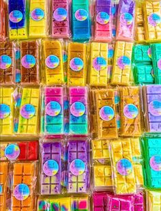 many different colored chocolates are stacked on top of each other in plastic wrappers