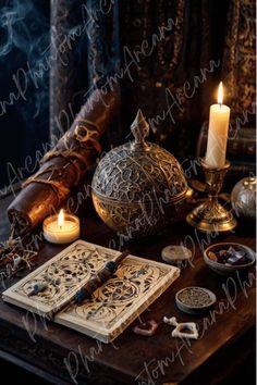 an open book sitting on top of a wooden table next to candles and other items