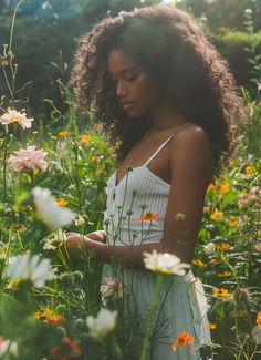 a woman in a field of flowers looking at her cell phone