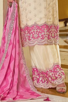 Experience elegance with the Ivory & Pink Chinon Silk Embroidered Palazzo Suit. Detailed thread work and sequins adorn this captivating design, making it the ideal choice for festivals and parties. Paired with a matching silk palazzo bottom and full size digital print dupatta, this suit exudes added elegance. Kameez chinon silk with embroidery work Palazzo chinon with embroidery work Dupatta chiffon silk with lace border, tassels Top Length: 46" Bottom Length: 40" Sleeves Length: 20" Santoon lining on top and bottom Work: Embroidered Side slit Neck Line: Round Occasion: party wear, festivals Dry clean Off White Chanderi Sets With Mirror Work, Fitted Cream Palazzo Set With Dupatta, Elegant Off White Palazzo Set With Mirror Work, Cream Palazzo Set With Dabka Work In Traditional Drape, Cream Semi-stitched Salwar Kameez For Reception, Traditional Semi-stitched Cream Palazzo Set, Semi-stitched Cream Salwar Kameez For Reception, Cream Palazzo Set With Mirror Work For Eid, Elegant Beige Salwar Kameez For Reception