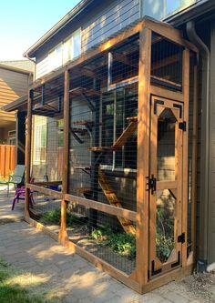 an outdoor chicken coop in front of a house