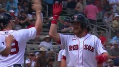 two boston red sox baseball players high fiving each other