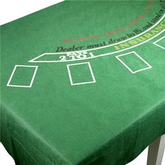 a green table cloth with white numbers on it and a blackjack logo at the top