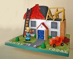 a birthday cake with a fireman next to a house and ladder on top of it