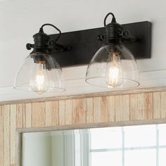 two light fixtures mounted on the wall above a mirror