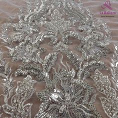 the fabric has been sequinized with silver flowers and leaves on it's side