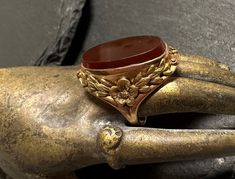 "10k yellow and green gold early 1900s ring-hand wrought, oval bezel set Carnelian(17x10mm), aesthetic design.  Small size 3, wt.- 3.2 grams, 3/4\" north to south on finger.  The ring is yellow gold with green gold hand wrought flowers and leaves sodered to form this elegantly framed stone-photos show details.  Condition is very good any slight wear is commensurate with age.  Earthy color in artist designed ring." 1900s Ring, Antique Ring, Ring Hand, Gold Hand, Ring Oval, Gold Hands, Yellow And Green, Earthy Colors, Aesthetic Design