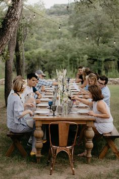 a group of people sitting around a wooden table