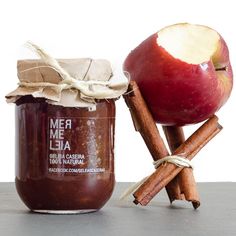 an apple and cinnamon stick next to a jar of jam