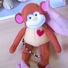 a stuffed monkey is being held by someone's hand