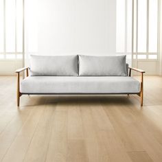 a white couch sitting on top of a hard wood floor