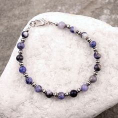 Small spheres of blue sodalite gemstones flaunt their colorful swirls of blue and cream in between silver pewter beads on this dainty bracelet. -- blue sodalite, silver pewter -- lobster clasp ** view our other bracelets here: https://www.etsy.com/shop/MoudyMercantile?ref=l2-shopheader-name§ion_id=22792437 Moudy Mercantile jewelry is handmade with pride in Waco, TX, using high-quality materials. Natural variations in the gemstones, beads and leather used in each piece are to be expected. Screen Bohemian Blue Sterling Silver Bracelet With Natural Stones, Sodalite Round Beads Jewelry For Healing, Blue Natural Stones Sterling Silver Bracelets, Sodalite Round Beads Bracelets As Gifts, Adjustable Sodalite Beaded Bracelets With Round Beads, Sodalite Round Beads Bracelets For Healing, Sodalite Bead Bracelets As Gift, Adjustable Sodalite Gemstone Beaded Bracelets, Adjustable Blue Sterling Silver Nickel-free Bracelet