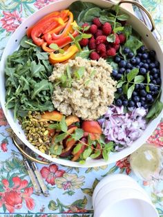 a bowl filled with berries, blueberries and other vegetables on top of a table