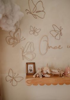 there is a shelf with some decorations on it and butterflies above the shelves in the room