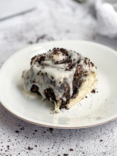 a white plate topped with a piece of cake covered in frosting