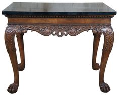 an ornate wooden table with black marble top