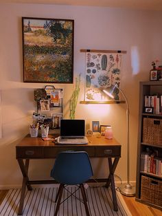 a laptop computer sitting on top of a wooden desk in front of a book shelf