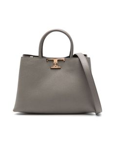 Colour: Dove grey Composition: Calf leather 100% Year: 2024 Made in: Italy Style ID: XBWTSQF0200XWZC404 Measurements: Width: 28cm x Height: 20cm x Depth: 12cm Handle: 27cm Strap: 100cm Crafted from the finest calf leather, this shoulder bag showcases a grained texture that exudes timeless elegance. The piece is secured with a logo-buckle twist-lock, complemented by a concealed magnetic fastening for added security. It features two rolled top handles alongside an adjustable and detachable shoulder strap for versatile styling options. The compartmentalised interior includes an internal logo stamp and patch pocket, all enveloped in a luxurious leather lining, finished with exquisite gold-tone hardware. * There may be a slight difference in the tone of colors depending on the resolution of you Tods Bag, Chic Logo, Texture Logo, Stylish Logo, Classy Lady, Leather Cap, Logo Stamp, Leather Care, Womens Tote