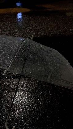 an open umbrella sitting in the rain at night