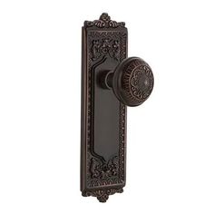 an antique style door handle with ornate carvings on the front and side panels, in dark bronze