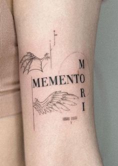 a woman with a tattoo on her arm that reads, mementoo iri