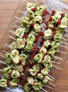 several skewered food items are on a clear platter with toothpicks and ketchup