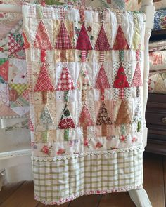 a quilt hanging on the side of a bed