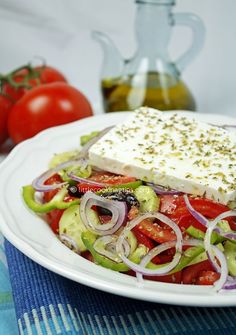 a salad with tomatoes, onions, cucumbers and feta cheese on it