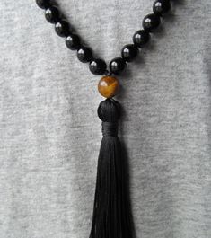 "Gorgeous traditional 108 bead mala made with authentic and high quality black onyx and tiger eye for the guru bead and spacers. The mala is finished with a hand tied black silk tassel, or optional no tassel. Mala measures 36\" around. Materials: 8mm black onyx beads 8mm tiger eye beads 10mm tiger eye bead Black knotting thread Black hand tied cotton tassel (optional) * All jewelry is handmade by me with care in my home studio using the finest gems and highest quality materials. * I pride myself Black 108 Beads Mala For Meditation, Black Mala With 108 Beads For Meditation, Traditional Hand-strung Black Mala, Traditional Black Hand-strung Mala, Traditional Black Mala With 8mm Beads, Traditional Black Mala With 108 Beads, Hand-strung Black Mala For Meditation, Black Hand-strung Mala For Meditation, Black Spiritual Mala For Healing