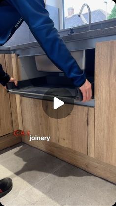 a person is opening up a cabinet in the kitchen with their feet on the counter