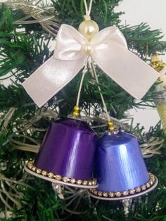 two bells are hanging from a christmas tree