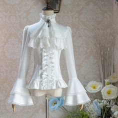 A cavalier blouse inspired by medieval knights. The neckline is decorated with bold frills and the cuffs are flared. The design beautifully accentuates the waistline. An elegant item that will be loved for generations to come. <Size> Small size Length: 57cm Shoulder width: 33cm Bust: 80-88cm Waist: 59-67cm Sleeve length: 65cm Medium size Length: 59cm Shoulder width: 36cm Bust: 90-98cm Waist: 69-77cm Sleeve length: 66cm Large size Length: 61cm Shoulder width: 40cm Bust: 100-108cm Waist: 79- Gothic Formal Tops With Ruffles, Elegant Doll Collar Blouse With Ruffles, White Fitted Top For Costume Party, Wedding Blouse With Ruffles And Ruffled Collar, Fitted Long Sleeve Cosplay Blouse, Gothic Ruffled Blouse For Formal Occasions, Gothic Ruffle Blouse For Formal Occasions, Elegant Puff Sleeve Blouse With Ruffle Hem, Fitted White Blouse With Ruffle Hem