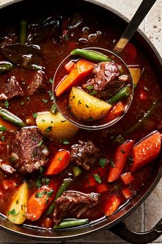 a pot filled with stew and vegetables on top of a table