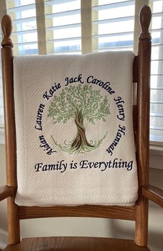 a chair with a blanket on it that says, family is everything in front of the window