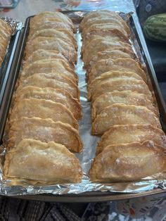 two pans filled with food sitting on top of tinfoil covered baking trays