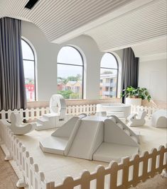 a room with large windows and white furniture in front of two huge windows, all made out of cardboard