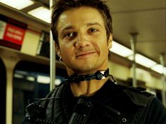 a man wearing a leather jacket and harness on a subway