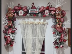 a window decorated with red and silver ornaments, christmas decorations, and candy canes