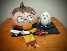 two pumpkins decorated to look like harry potter and an owl sitting on a table